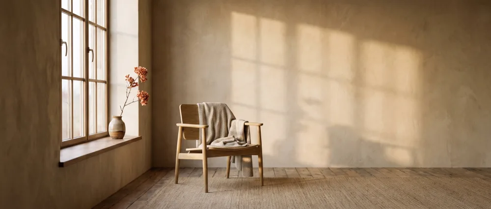 An empty chair with a folded throw in morning light